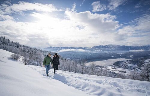 Zwei Menschen gehen Hand in Hand im Schnee spazieren